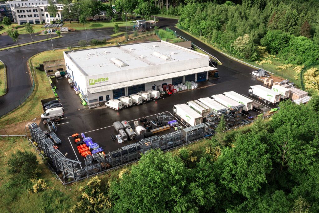 Luftaufnahme des MuHTec Firmengeländes mit Lagerhalle, Fuhrpark und landwirtschaftlicher Technik