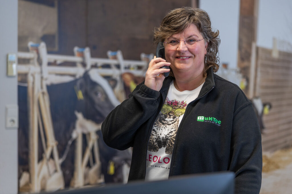 Mitarbeiterin im Büro vor Kuhmotiv im Hintergrund