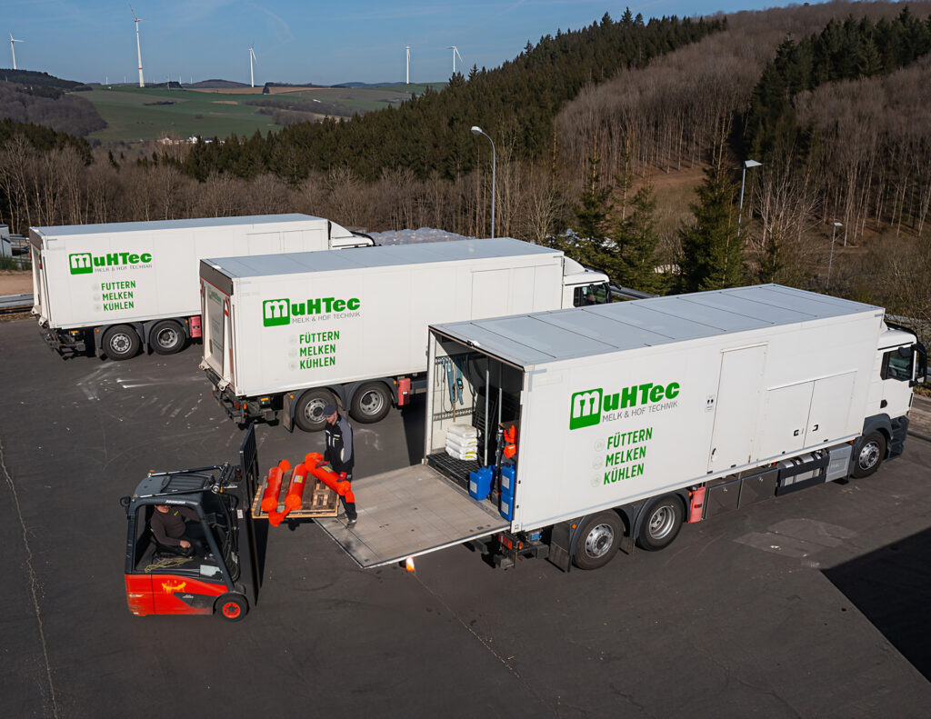 Mehrere Lkw werden mit Gabelstapler auf einem Hof beladen